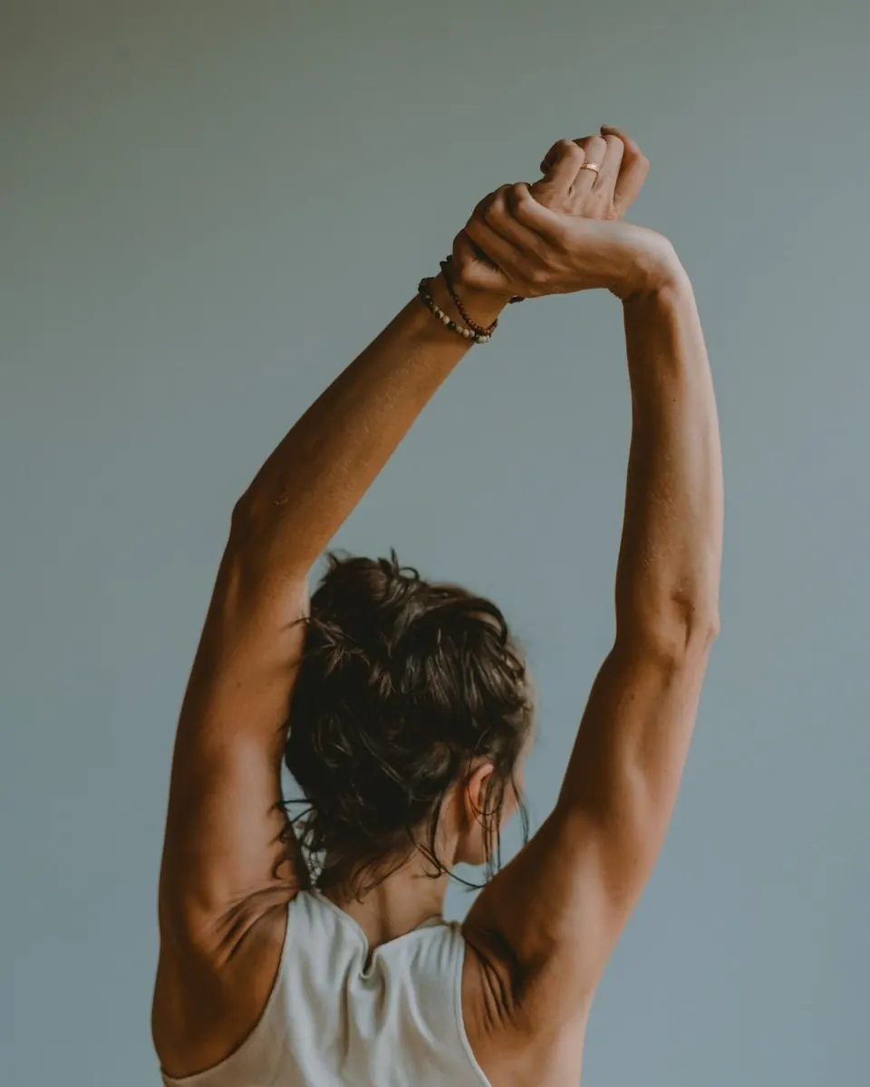 A woman gently stretching her arms overhead